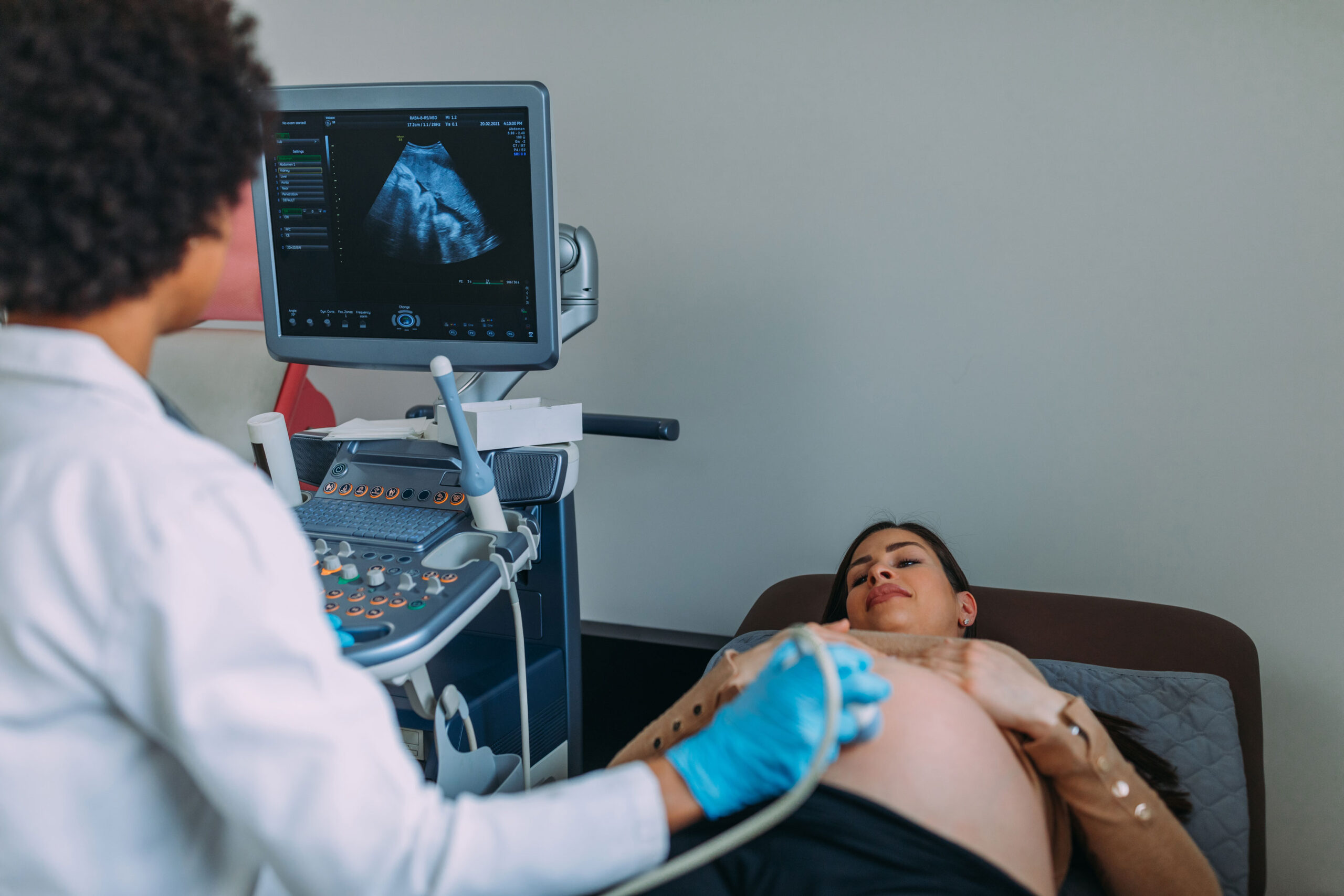 A medical provider performs an ultrasound on a pregnant woman.