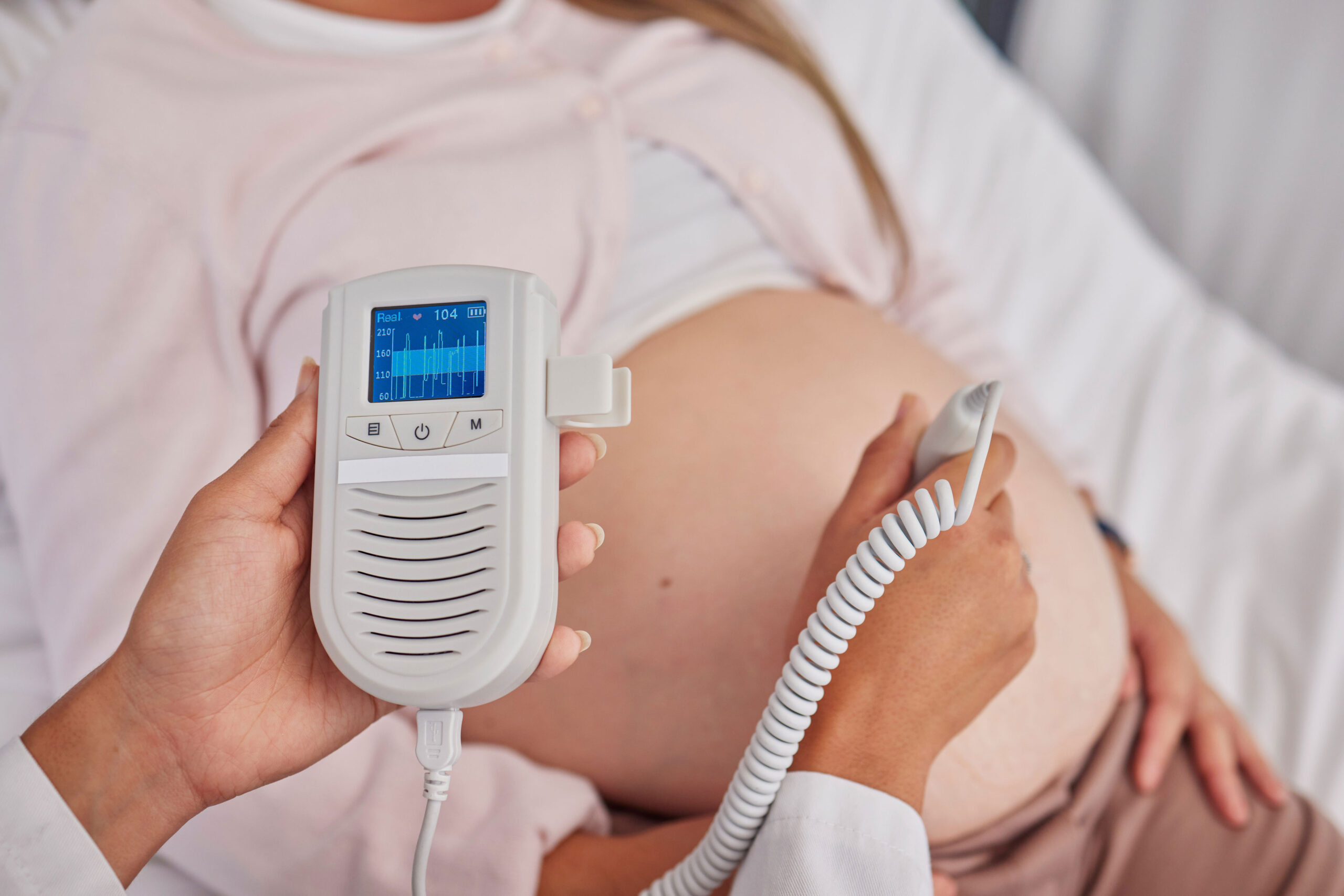 A medical provider performs fetal monitoring on a pregnant woman.